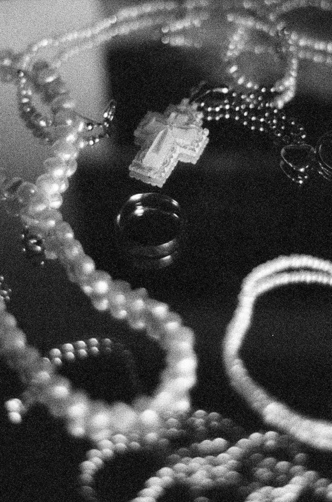 black and white close up of jewelry on a mirrored surface