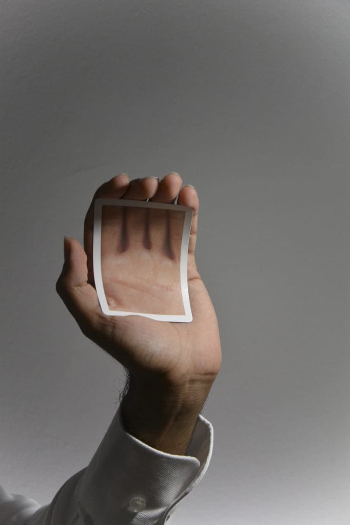 a hand holding a picture of a hand in front of a white background