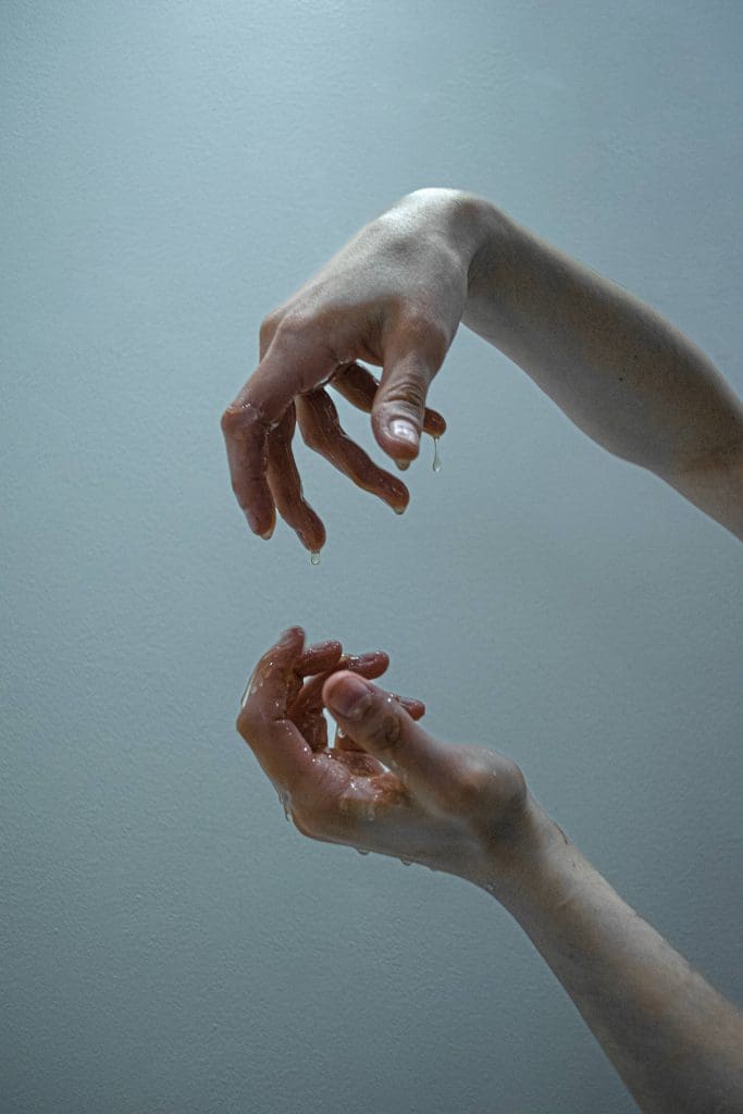 two hands covered in honey in front of a blue background