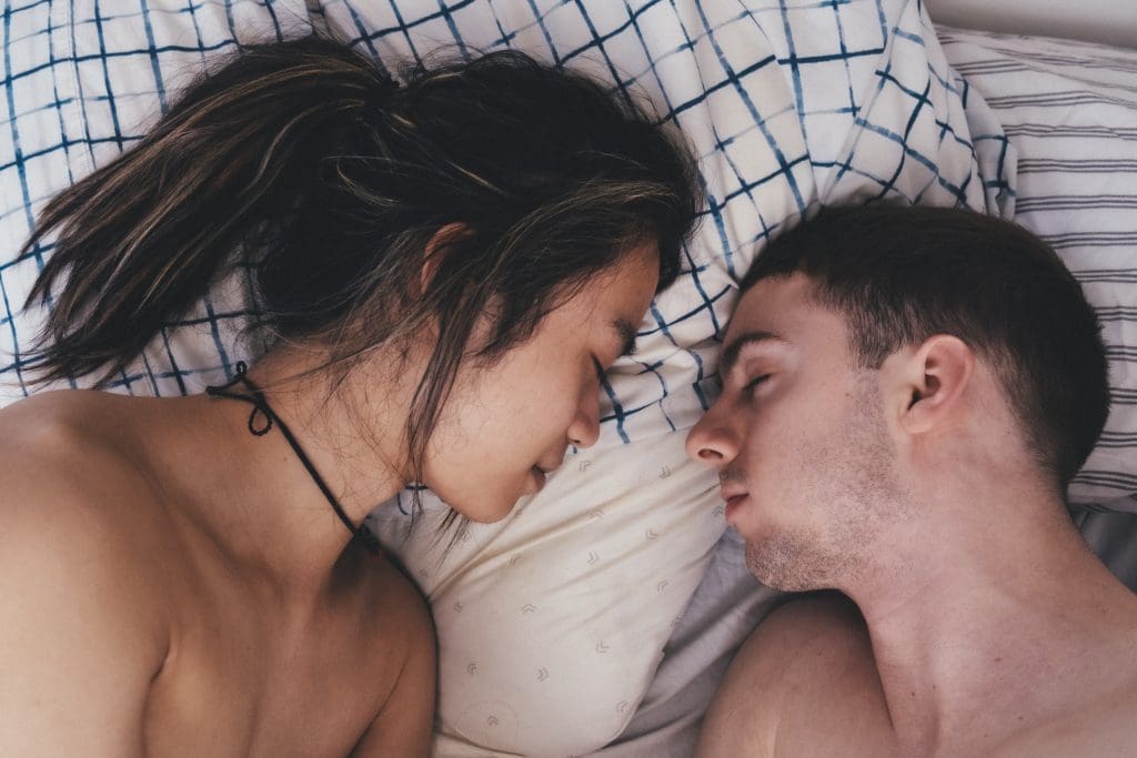 Color close up image of two men sleeping next to each other in bed