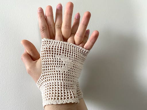 white weaved gloves on two hands clasped together