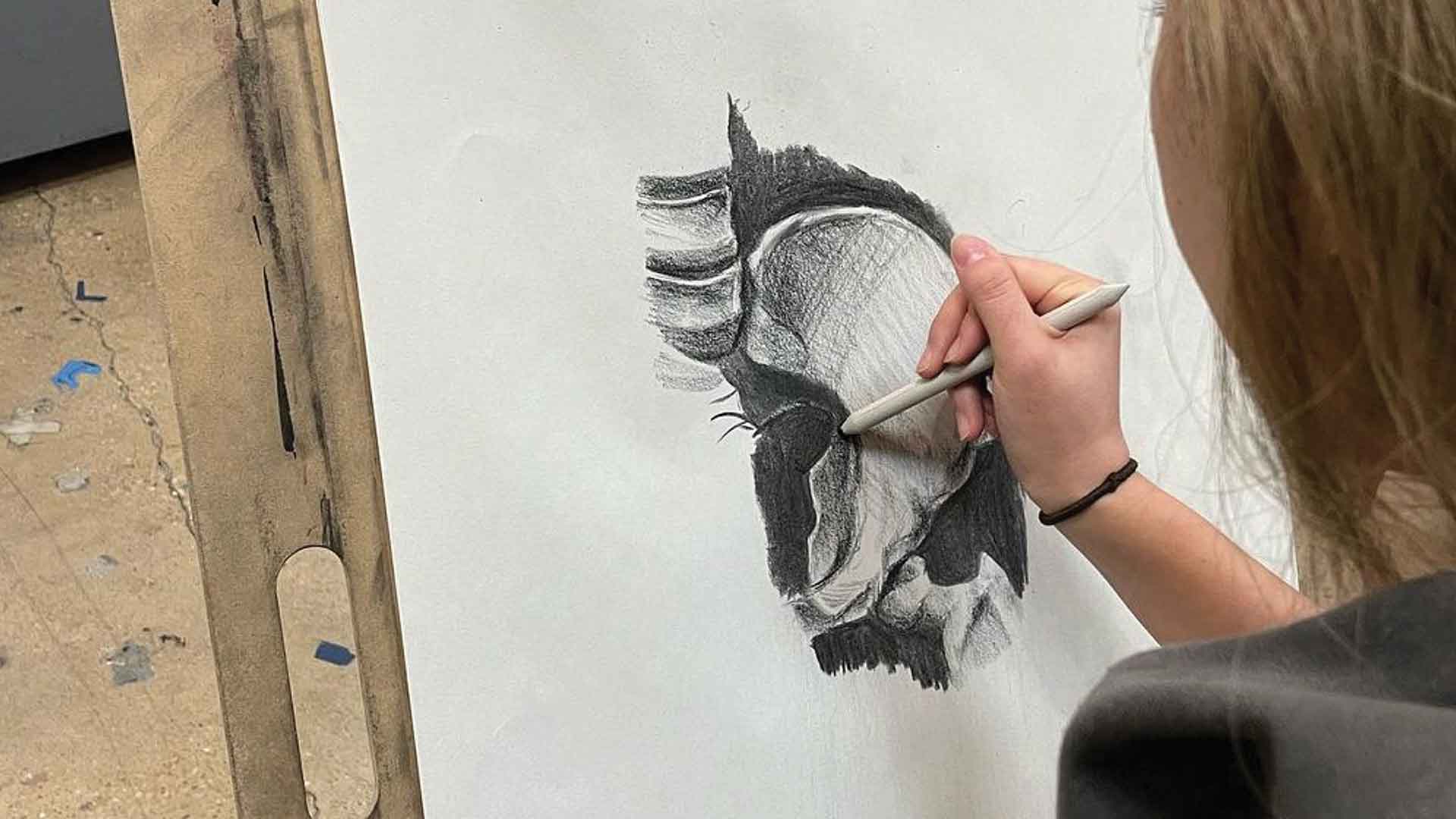 student drawing with charcoal