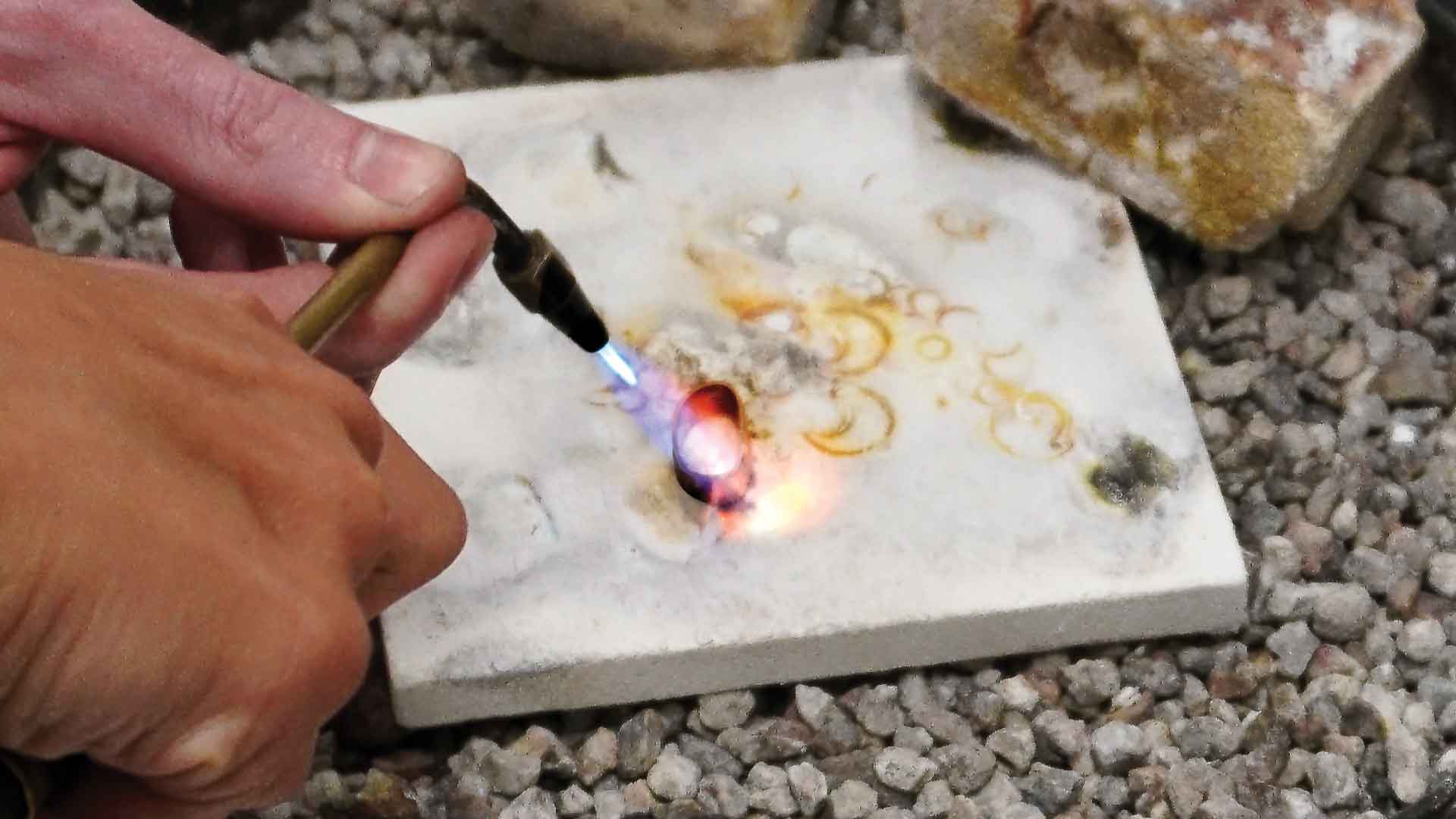 image of using an open flame to bond metal together when making jewelry