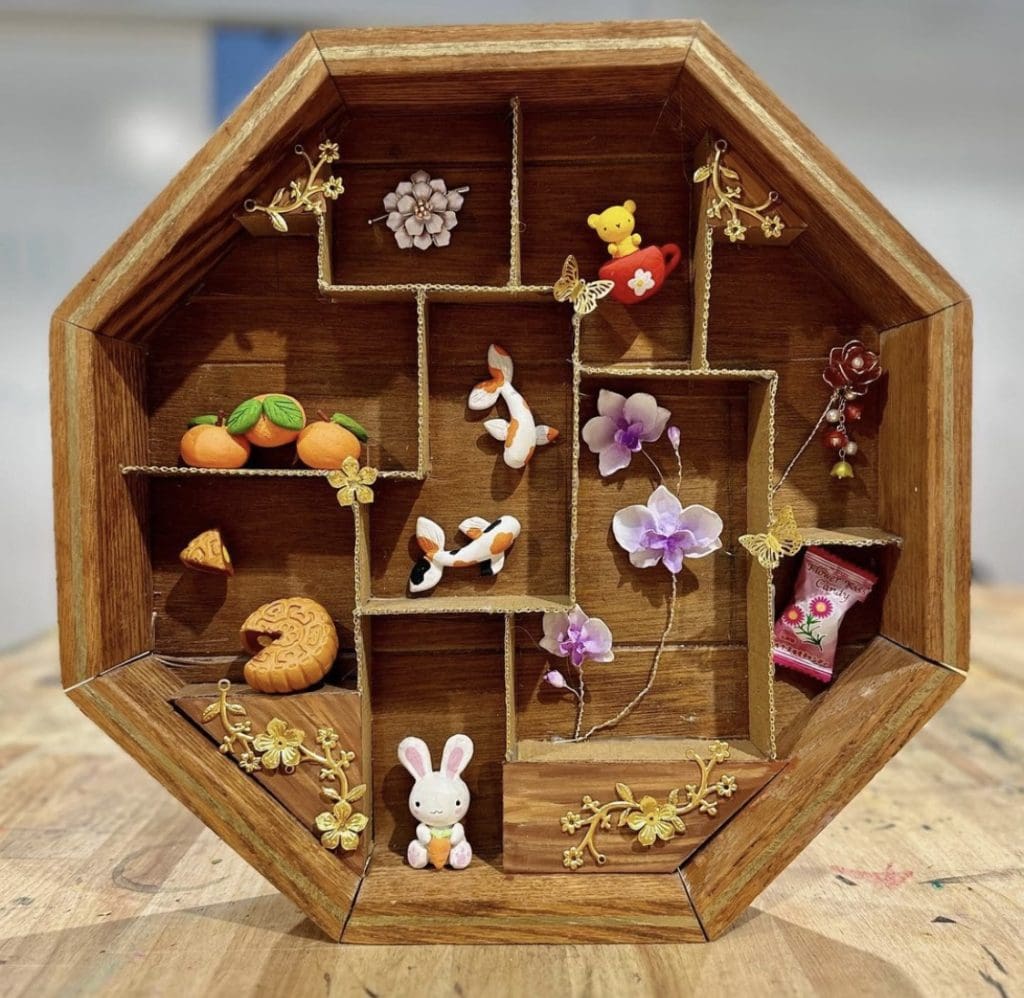 sculpture of small items in wooden octagon 