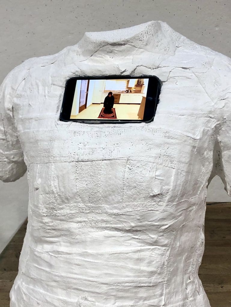 a 3D plaster bust with a iphone set inside its chest