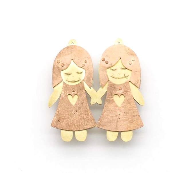 brooch pin of two twin girls holding hands