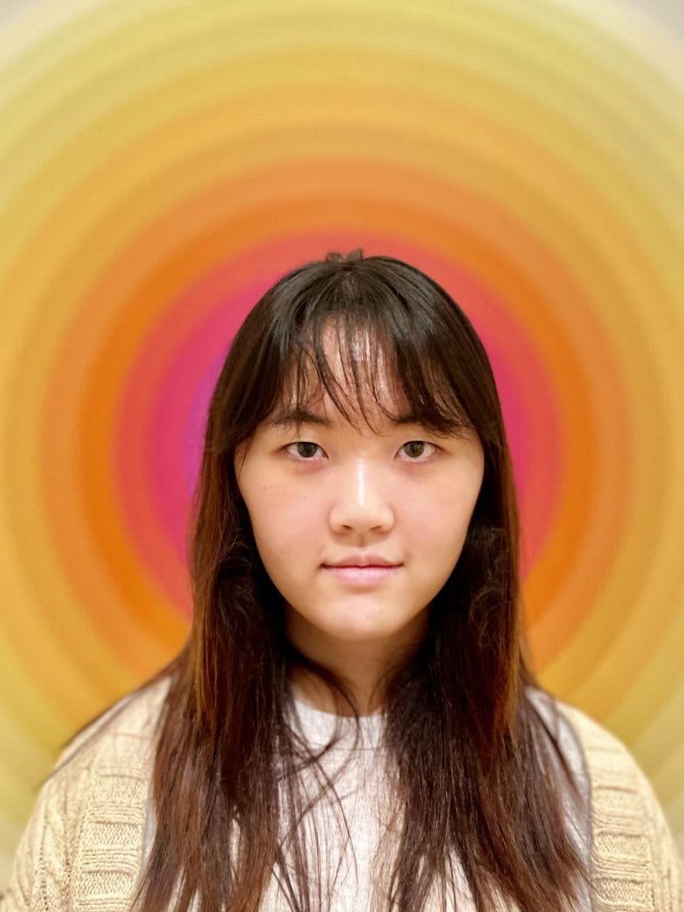 portrait of a girl in front of an orange and pink circular background