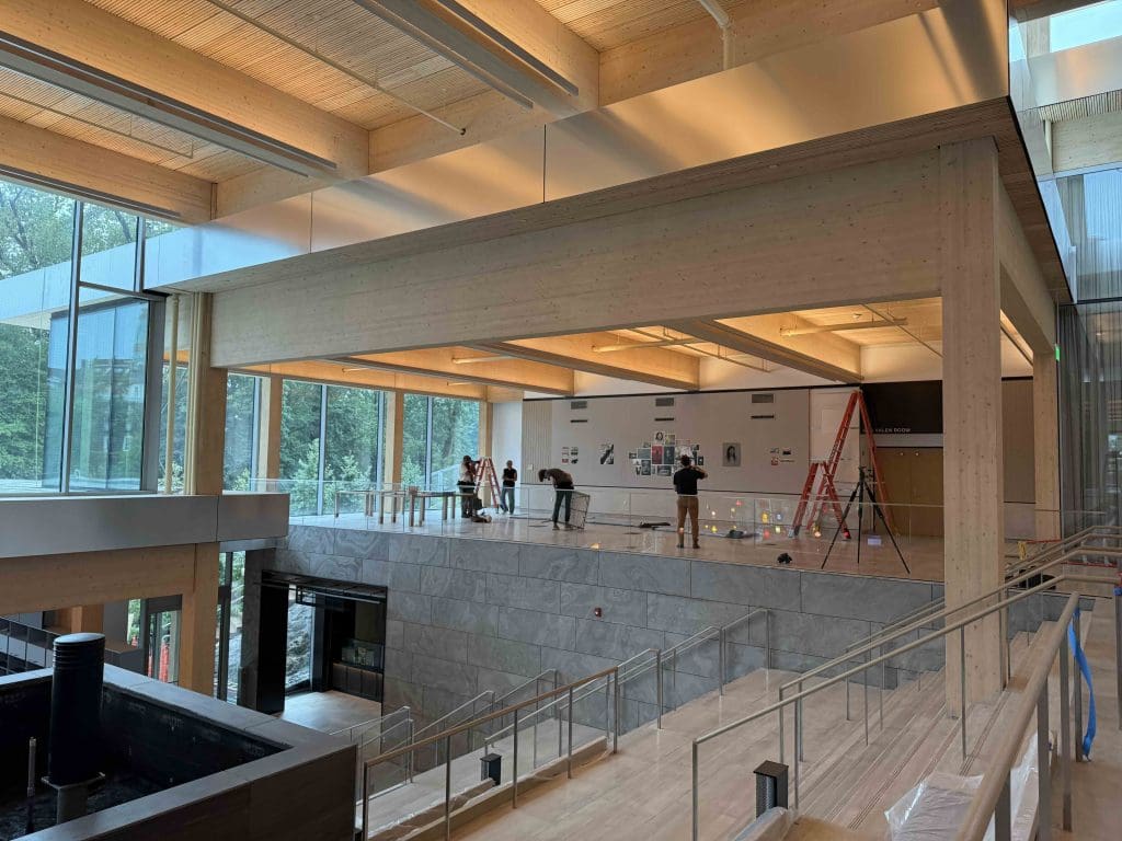  wide angle zoomed out image of people installing artworks at the new student center