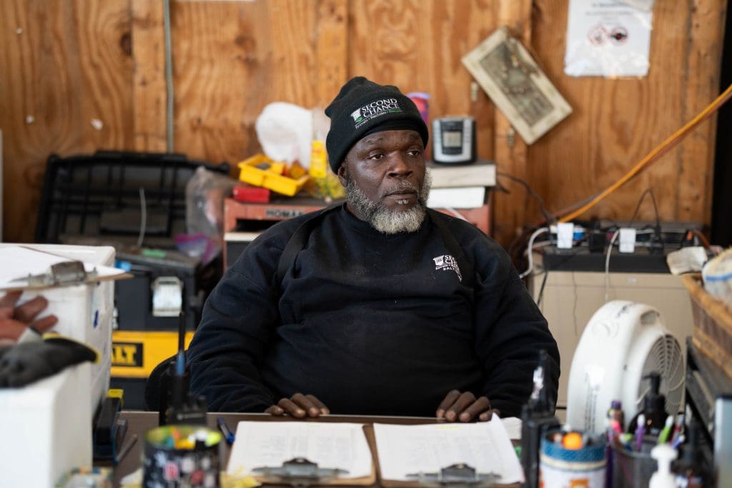 a man in an office wearing a black beanie