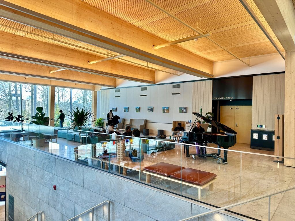 open room with wood ceiling, piano and glass railing