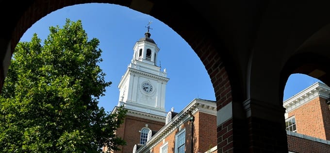 a view of Gilman Hall clock tower through brick archway