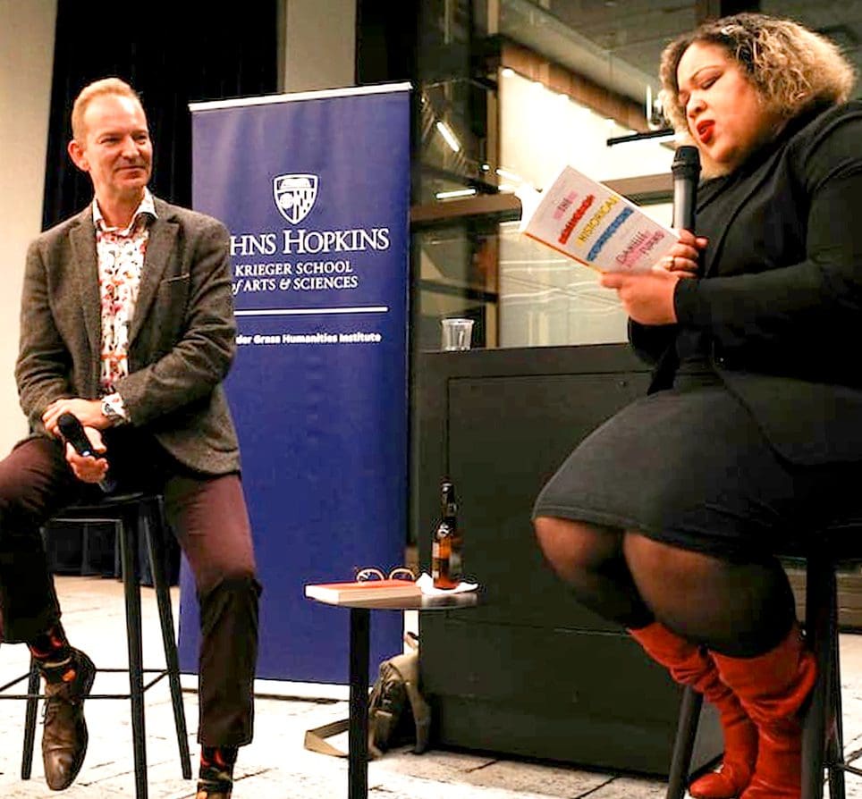 Danielle Evans reading from a book in front of Bill Egginton