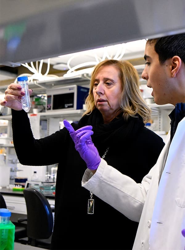 Professor DiRuggiero and student in discussion at biology lab bench.