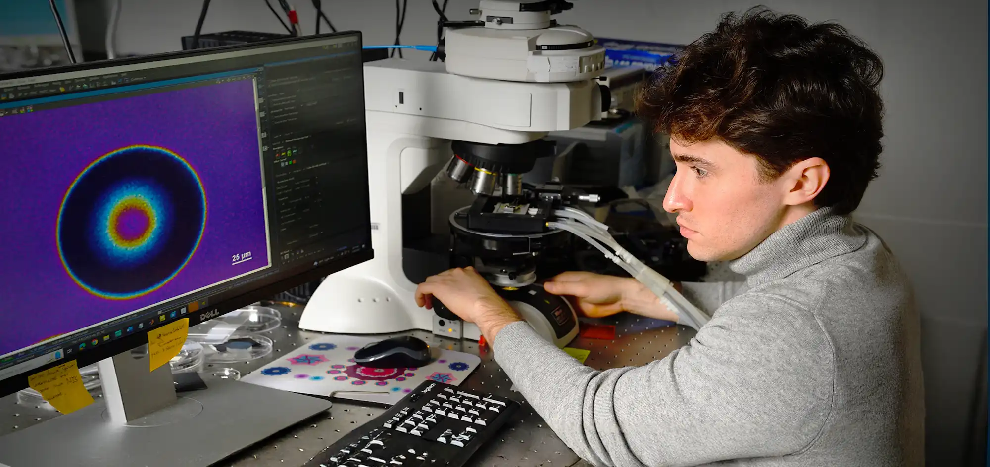 Physics and Astronomy PhD student seated at computer screen in lab.