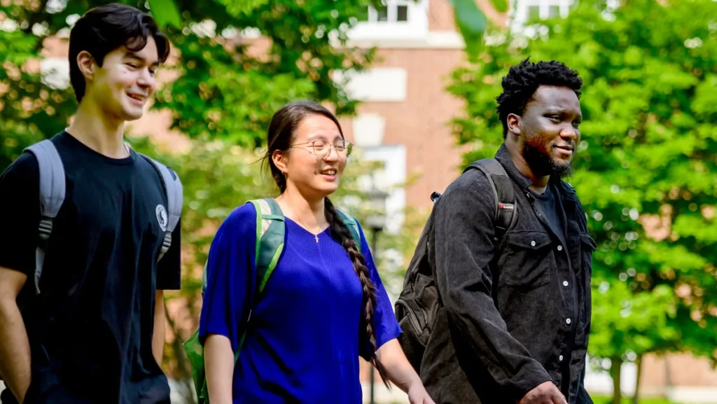 three students walking across campus 