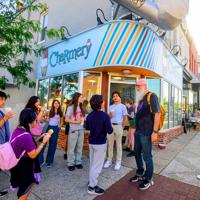 A professor with students outside The Charmery ice cream shop in the Hampden neighborhood near the Homewood campus.