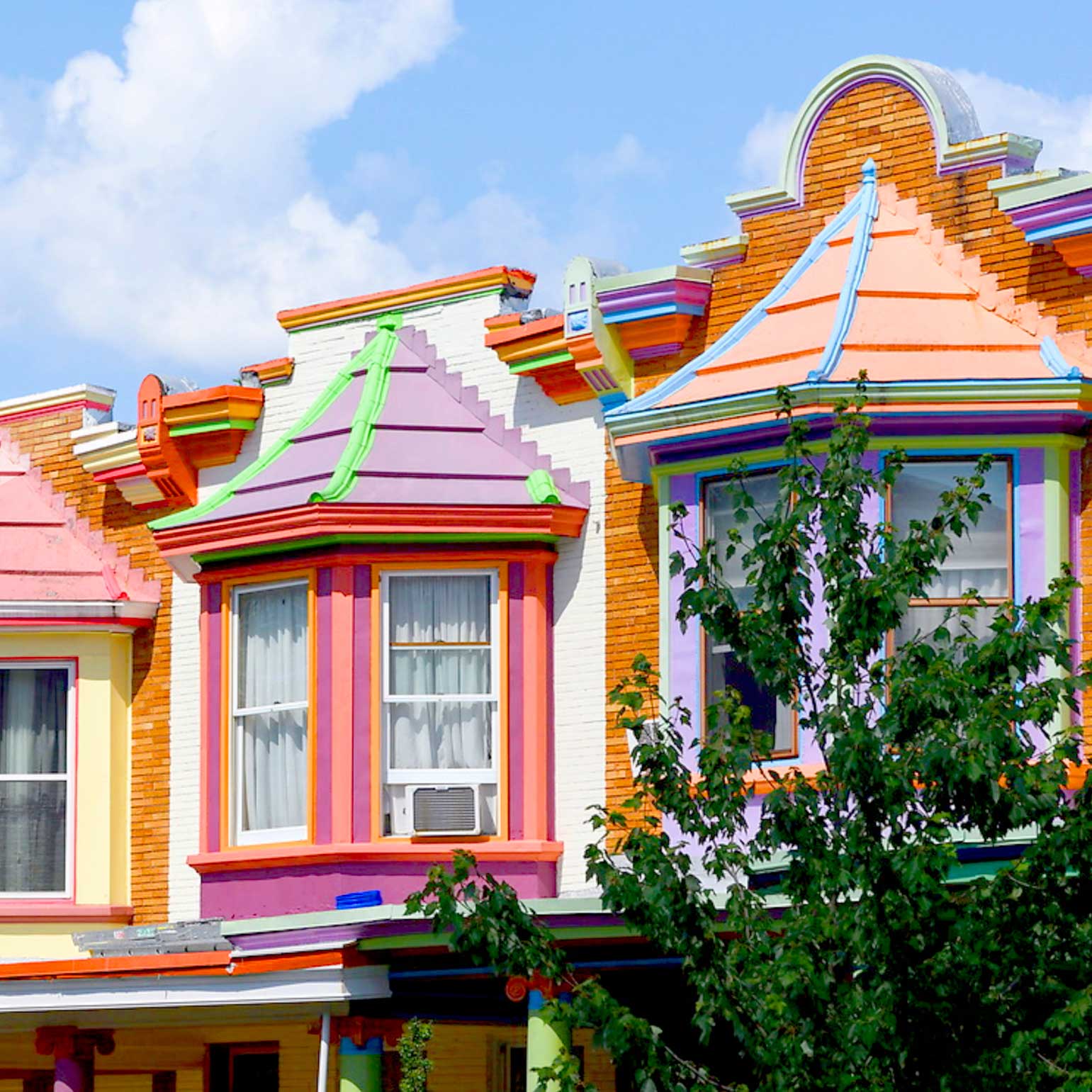 A vibrant row of colorfully painted bay windows on the “Painted Ladies” of Charles Village.