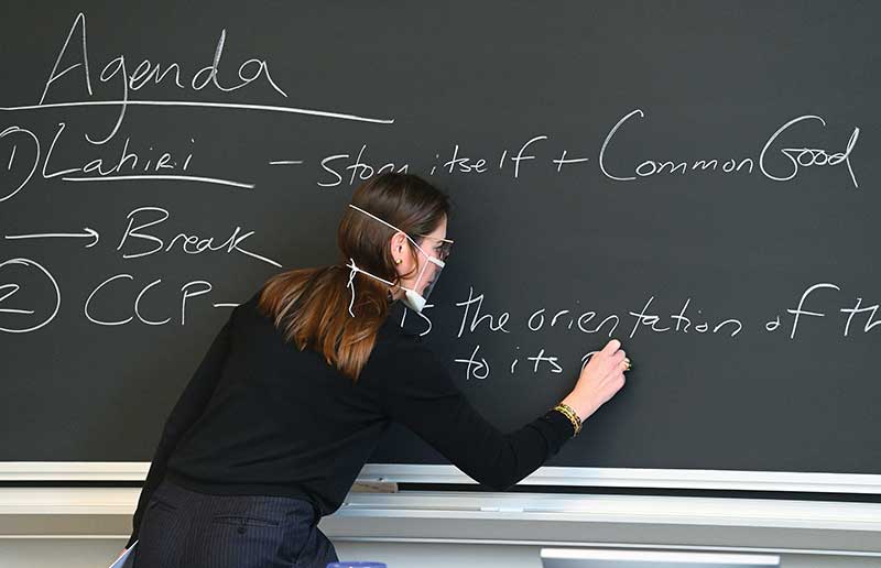 Aliza Watters writing on a chalkboard