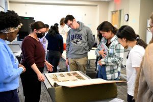 Professor Lurtz and students gather around an antique map