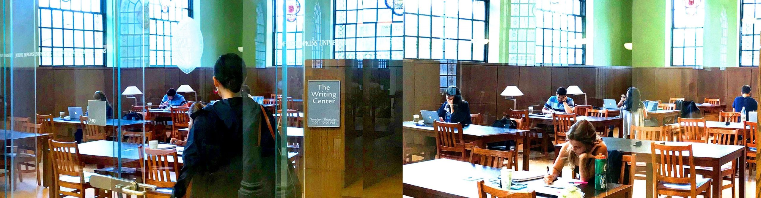 Students studying in a large room with stained glass windows